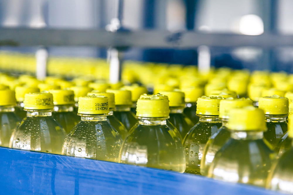 A lot of yellow bottles with yellow bottle caps. Background is blurry.