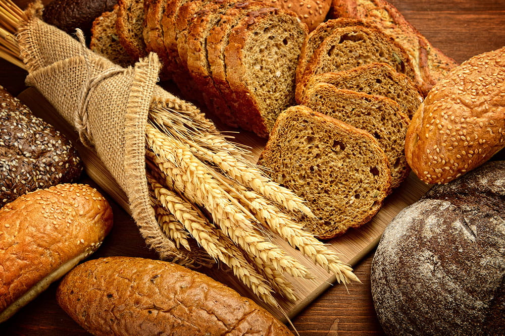 Brote und Brötchen umliegt in Leinen eingewickeltes Weizen mit einem Schwarzbrot