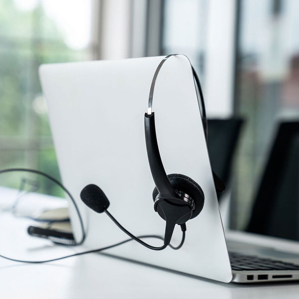 Headphones hanging over a laptop standing on a table